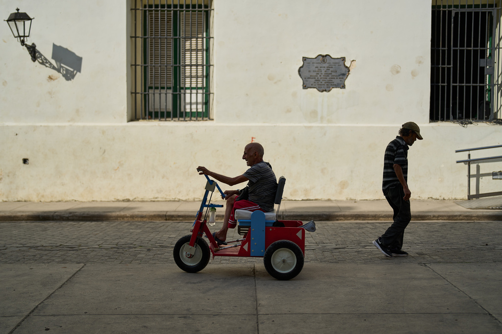 An elderly man who has an amputated leg rides a hand-powered tricycle in Old Havana. Cuba, Thursday, Feb. 20, 2025. (AP Photo/Ramon Espinosa)