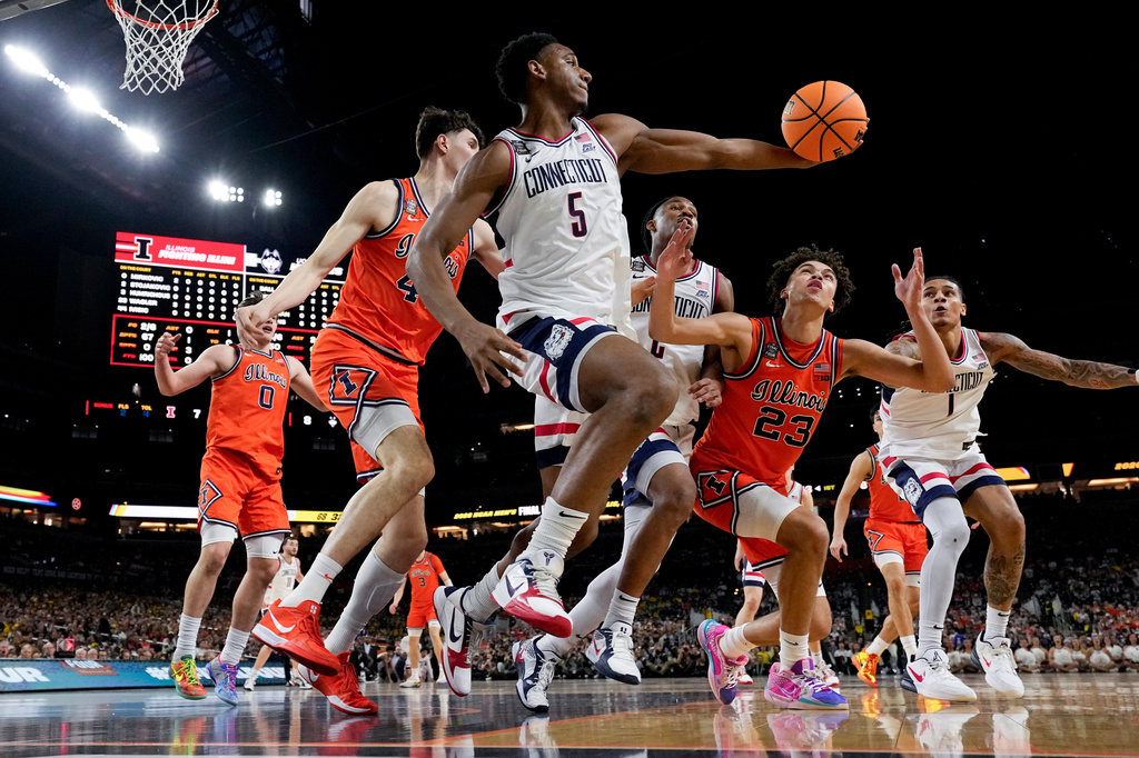 UConn forward Tarris Reed Jr. (5) rebounds as Illinois guard Keaton Wagler (23) pursues during the first half of an NCAA college basketball tournament semifinal game at the Final Four, Saturday, April 4, 2026, in Indianapolis. (AP Photo/Abbie Parr)