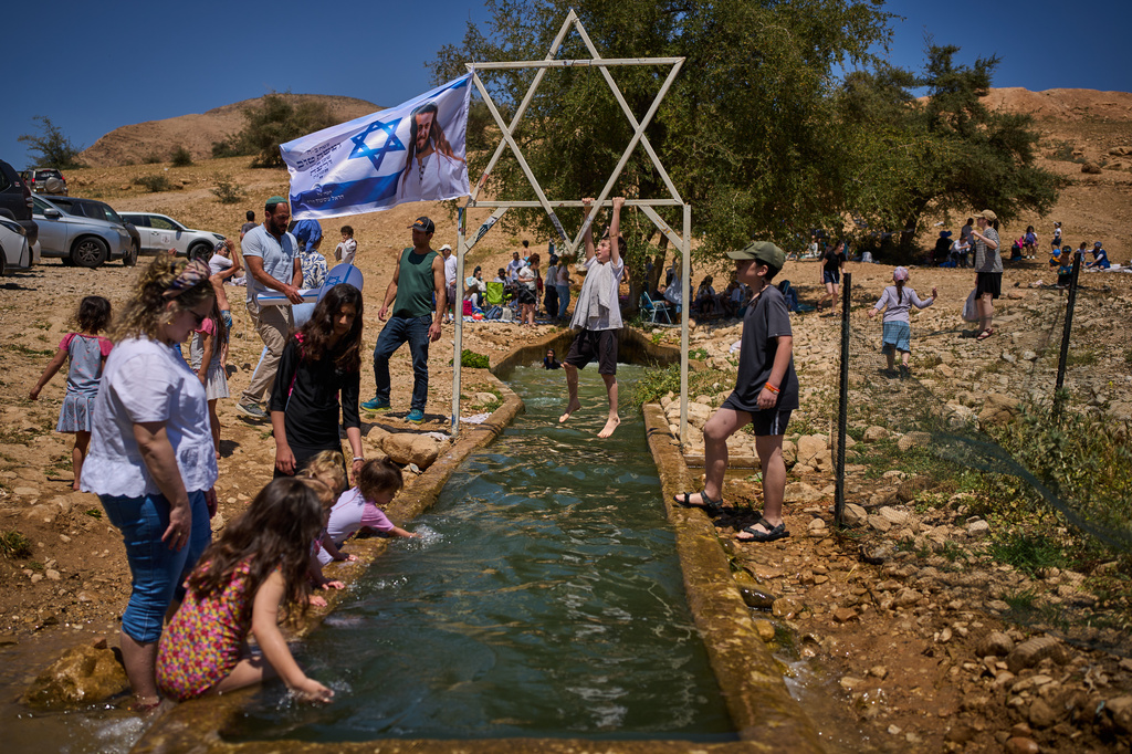 A child climbs on a metal Star of David structure at a spring in Auja, in the Jordan Valley, during Israel's Independence Day on April 22, 2026, in the occupied West Bank. (AP Photo/Ohad Zwigenberg)