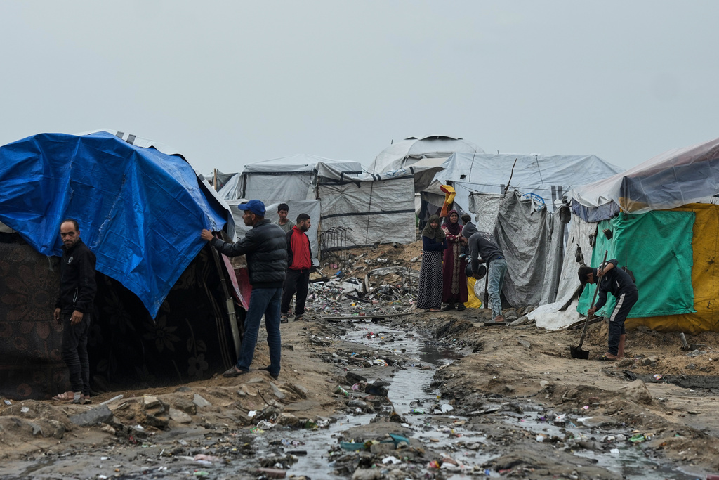 Displaced Palestinians repair their tents at a tent camp on the beach after a stormy weather in Gaza City, Wednesday, Dec. 10, 2025. (AP Photo/Jehad Alshrafi)