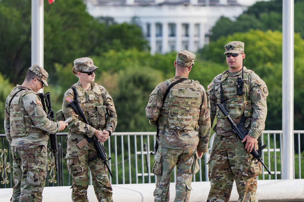 FILE - With the White House in the distance, National Guard troops patrol the Mall as part of President Donald Trump's order to impose federal law enforcement in the nation's capital, in Washington, Aug. 28, 2025. (AP Photo/J. Scott Applewhite, File)