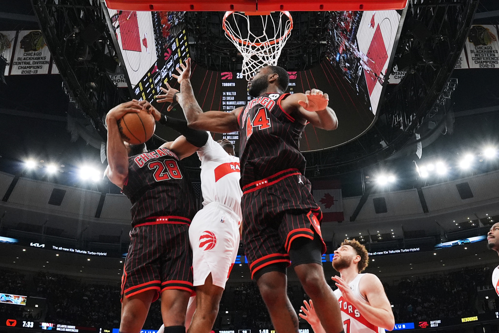 Chicago Bulls forward Guerschon Yabusele, left, battles for a rebound against forward Patrick Williams, right, and Toronto Raptors forward Brandon Ingram during the first half of an NBA basketball game in Chicago, Wednesday, March 18, 2026. (AP Photo/Nam Y. Huh)