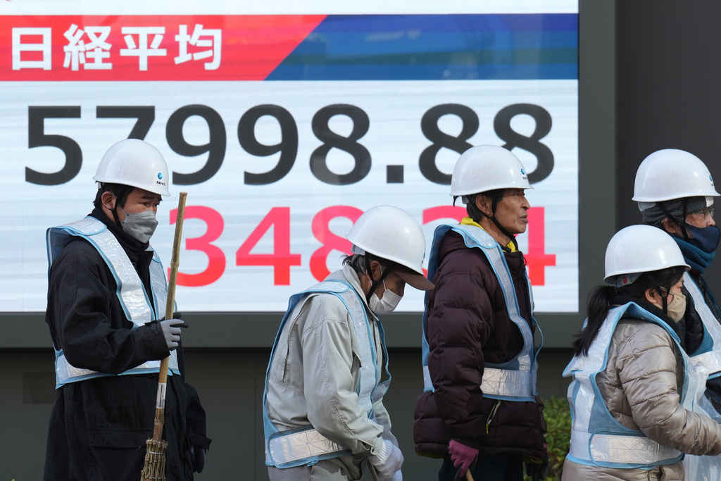 People walk in front of an electronic stock board showing Japan's Nikkei index at a securities firm Thursday, Feb. 12, 2026, in Tokyo. (AP Photo/Eugene Hoshiko)