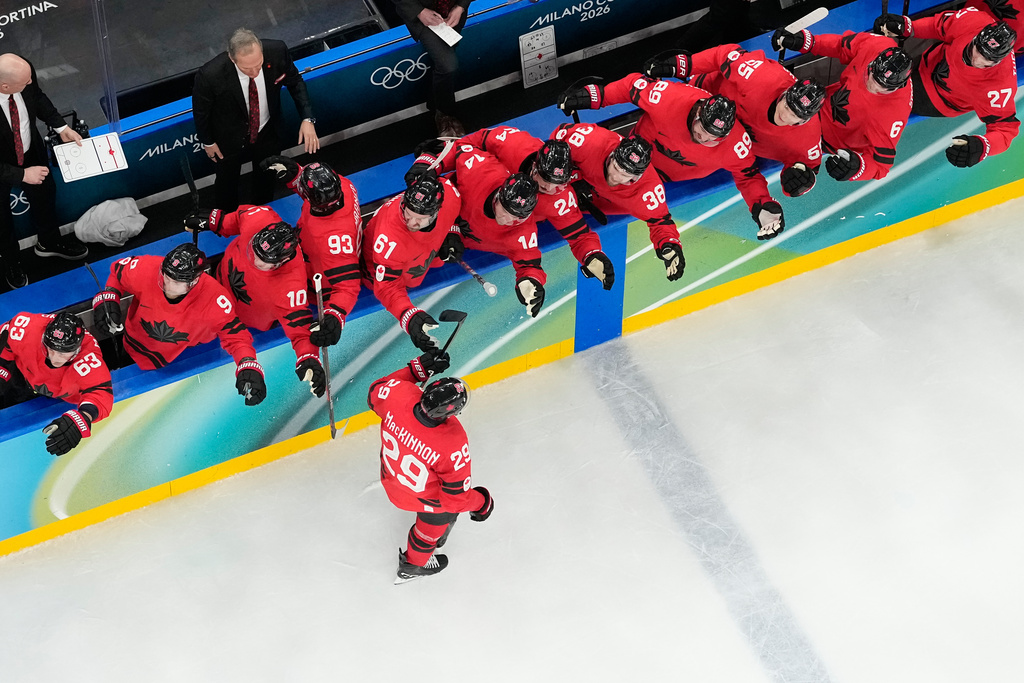 Canada's Nathan MacKinnon (29) celebrates with teammates after scoring the game-winning goal against Finland during a men's semifinal ice hockey game at the 2026 Winter Olympics, in Milan, Italy, Friday, Feb. 20, 2026. (AP Photo/David J. Phillip)