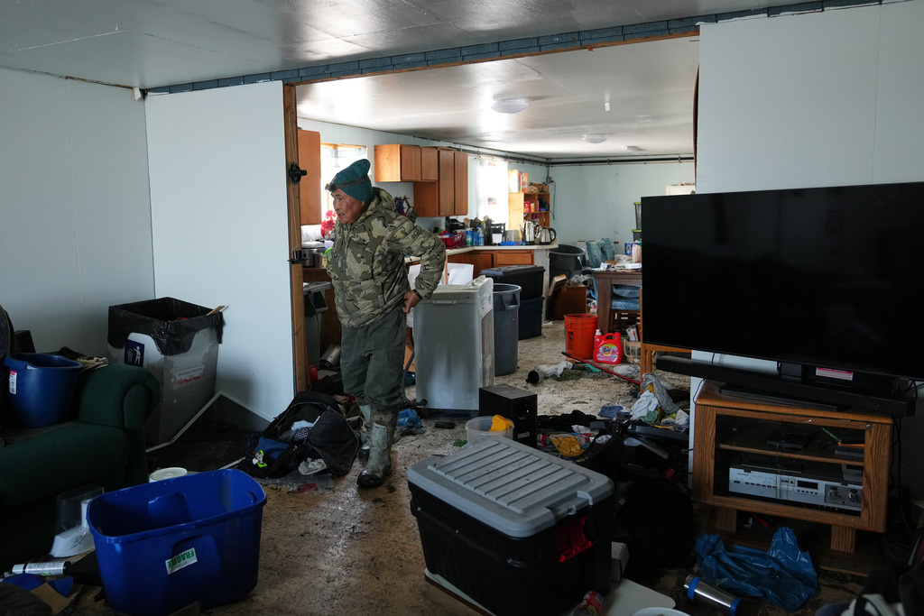 Harry Friend walks through his brother's flood-damaged home in Kwigillingok, Alaska, Monday, Oct. 27, 2025, after Typhoon Halong hit the area earlier in the month. (AP Photo/Lindsey Wasson)