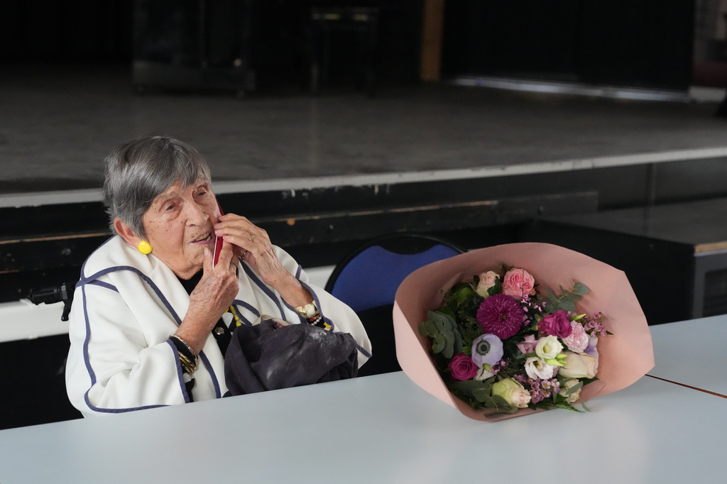 Ginette Kolinka, a 101-year-old survivor of Auschwitz, makes a phone call after she met some pupils in a Paris-region high school in Saint-Maur-des-Fosses, outside Paris, France, March 21, 2026. (AP Photo/Thibault Camus)