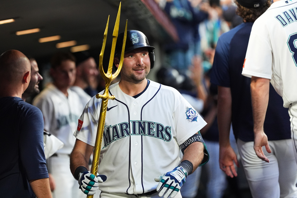 Seattle Mariners' Cal Raleigh celebrates in the dugout after hitting a grand slam against the Cincinnati Reds during the seventh inning of a baseball game, Monday, July 20, 2026, in Seattle. (AP Photo/Lindsey Wasson)