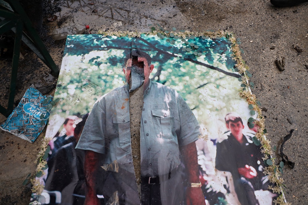 A defaced picture of Abdullah Ocalan, the imprisoned leader of the Kurdistan Workers' Party, or PKK, lies on the floor in the predominantly Kurdish Sheikh Maqsoud neighborhood in the northern city of Aleppo, Syria, Monday, Jan. 12, 2026, where clashes broke out on Jan. 6, between government forces and the Kurdish-led Syrian Democratic Forces. (AP Photo/Omar Albam)