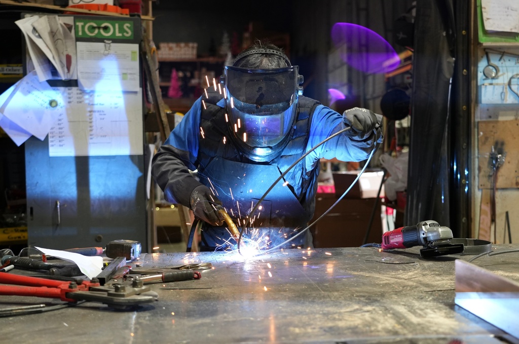 Juan Gonzalez assembles an artificial Christmas wreath at Lee Display's warehouse, in Fairfield, Calif., Tuesday, Dec. 9, 2025. (AP Photo/Terry Chea)