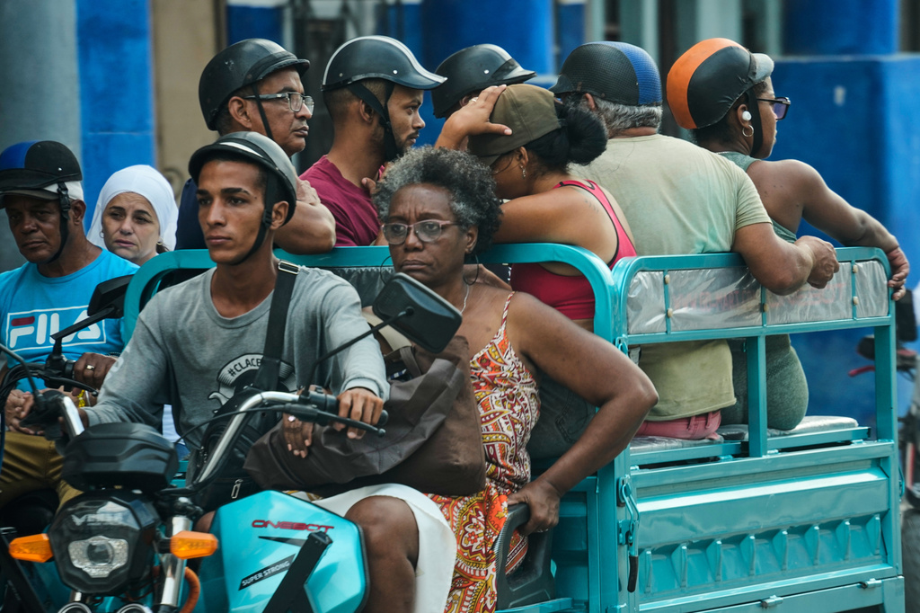 People travel on an electric tricycle in Havana, Cuba, Friday, May 8, 2026. (AP Photo/Ramon Espinosa)