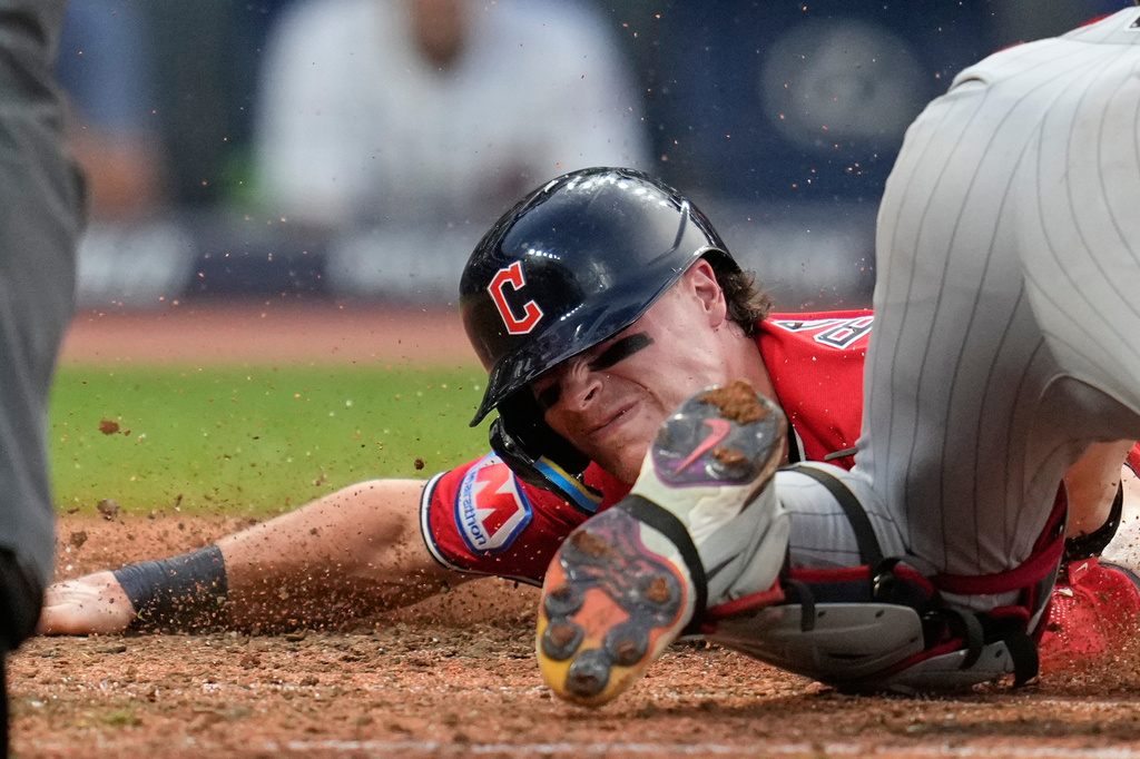 Cleveland Guardians' Travis Bazzana, left, scores under the tag of Minnesota Twins catcher Ryan Jeffers, right, in the sixth inning of a baseball game in Cleveland, Tuesday, July 21, 2026. (AP Photo/Sue Ogrocki)