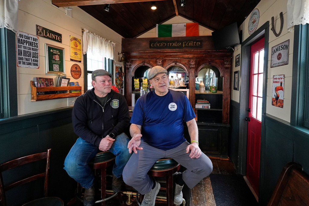 Brothers Matt Taylor, left, and Craig Taylor talk with a visitor in one of their tiny pubs Wednesday, March 11, 2026, in Reading, Mass. (AP Photo/Robert F. Bukaty)