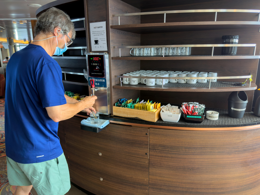 A passenger on the hantavirus-stricken cruise ship, MV Hondius, helps himself to water at the ship's self-service area during the voyage to Spain's port of Tenerife, May 6, 2026. (AP Photo)