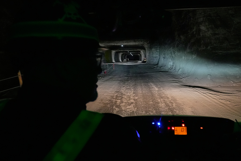 The headlights of the vehicle driven by George Campbell, left, maintenance supervisor, light the way through the tunnels of the Cargill Cleveland salt mine in Whiskey Island, to a current work location, 1,800 feet below the surface of Lake Erie and six miles from the entrance of the mine, in Cleveland, Ohio, Thursday, March 19, 2026. (AP Photo/Sue Ogrocki)