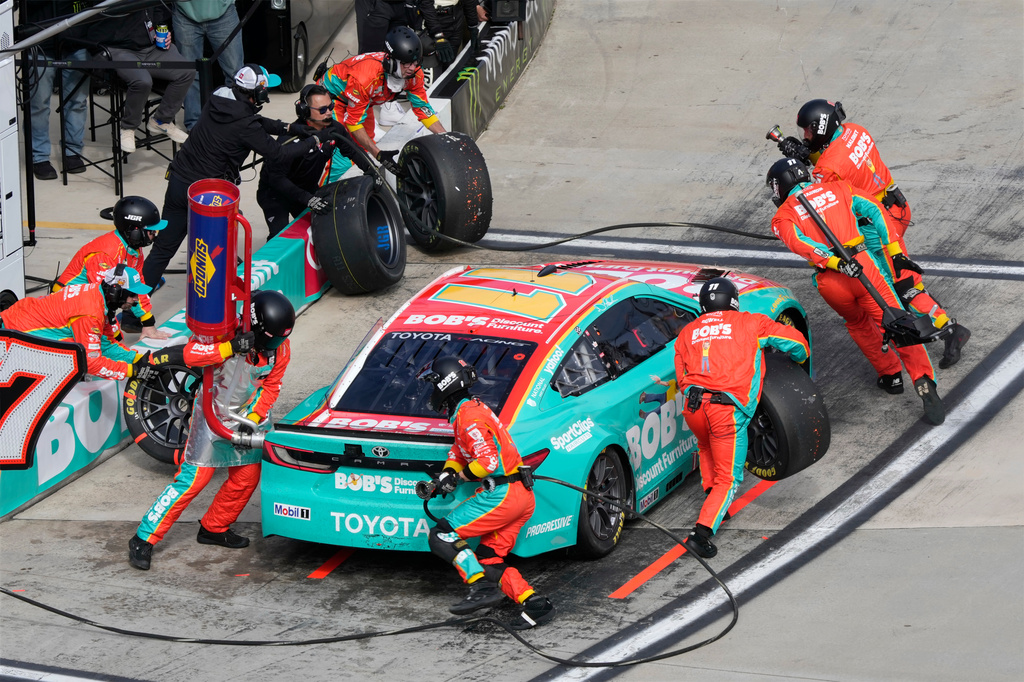 Crew members perform a pit stop on driver Denny Hamlin's car during a NASCAR Cup Series auto race in Martinsville, Va., Sunday, March 29, 2026. (AP Photo/Chuck Burton)