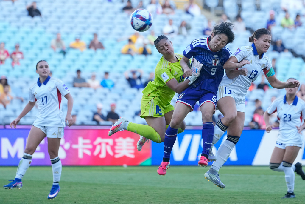 Japan's Riko Ueki attempts a shot on goal as she competes with Philippines' goalkeeper Nina Meollo and Angela Beard, right, during the Women's Asian Cup quarterfinal soccer match between Japan and the Philippines in Sydney, Sunday, March 15, 2026. (AP Photo/Rick Rycroft)