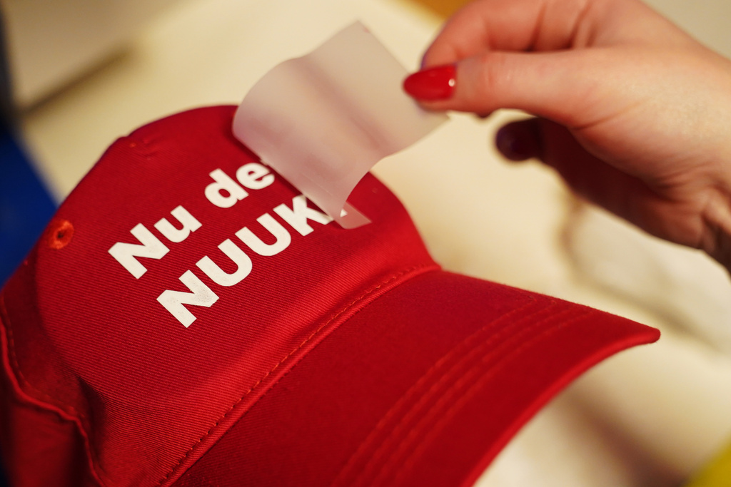 A worker prints a red cap for with the slogan "Nu det NUUK!," a twist on the Danish phrase “Nu det nok,” meaning “Now it’s enough,” substituting Nuuk, Greenland’s tiny capital, for sale at the store of the hat's creator Jesper Rabe Tonnesen in Copenhagen, Denmark, Friday, Jan. 16, 2026. (AP Photo/James Brooks)