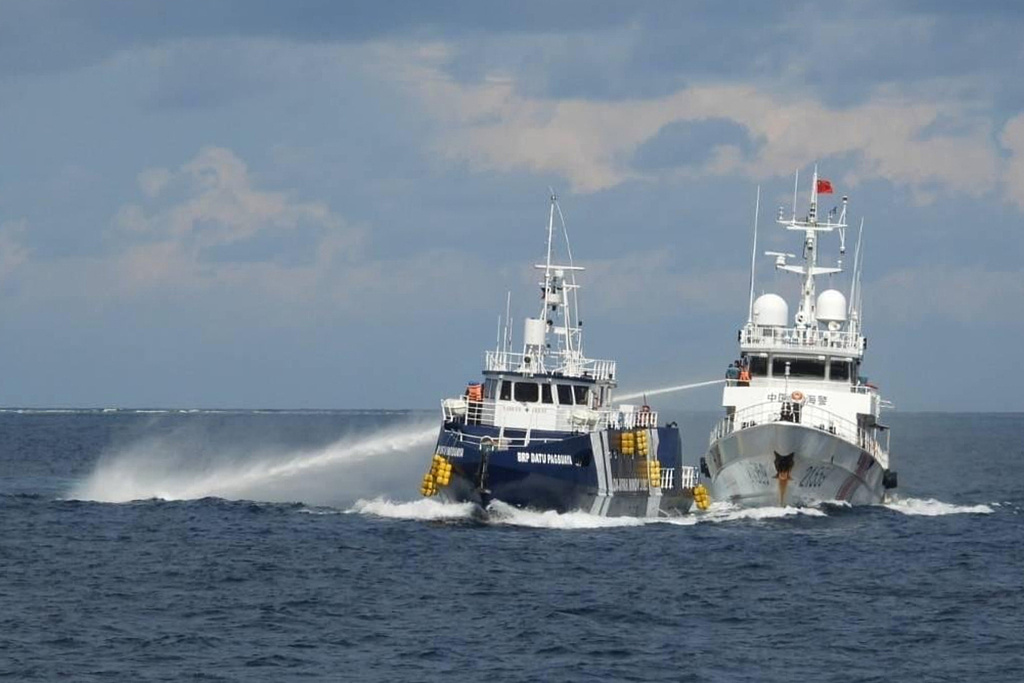 In this photo provided by the Philippine Coast Guard, a Chinese Coast Guard vessel, right, fires it's water cannon at the Philippine's BRP Datu Pagbuaya near Philippine occupied Thitu island locally called Pag-asa island at the South China Sea on Sunday Oct. 12, 2025. (Philippine Coast Guard via AP)