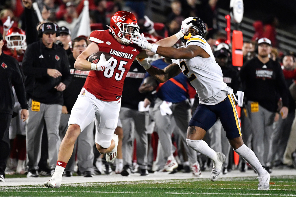 Louisville tight end Nate Kurisky (85) attempts to stiff-arm California defensive back Dru Polidore Jr. (2) during the second half of an NCAA college football game in Louisville, Ky., Saturday, Nov. 8, 2025. (AP Photo/Timothy D. Easley)