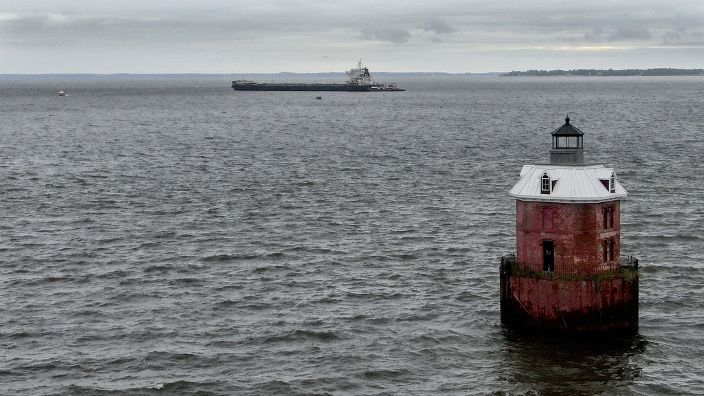 A Liberian commercial cargo vessel named W-Sapphire, that had an explosion late Monday on-board, is towed by tugboats near the Sandy Point Shoal Light in Annapolis, Md., Tuesday, Aug. 19, 2025, off the shore of the Sandy Point State Park. (Jeffrey F. Bill/The Baltimore Sun via AP)
