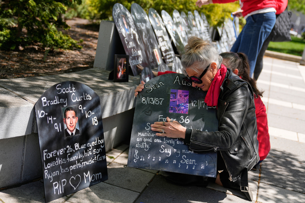 Tanny Austin cries while looking at tombstones with the names of victims of the opioid crisis, including her son Sean Austin, during a rally outside of a courthouse in Newark, N.J., Tuesday, April 21, 2026. (AP Photo/Seth Wenig)
