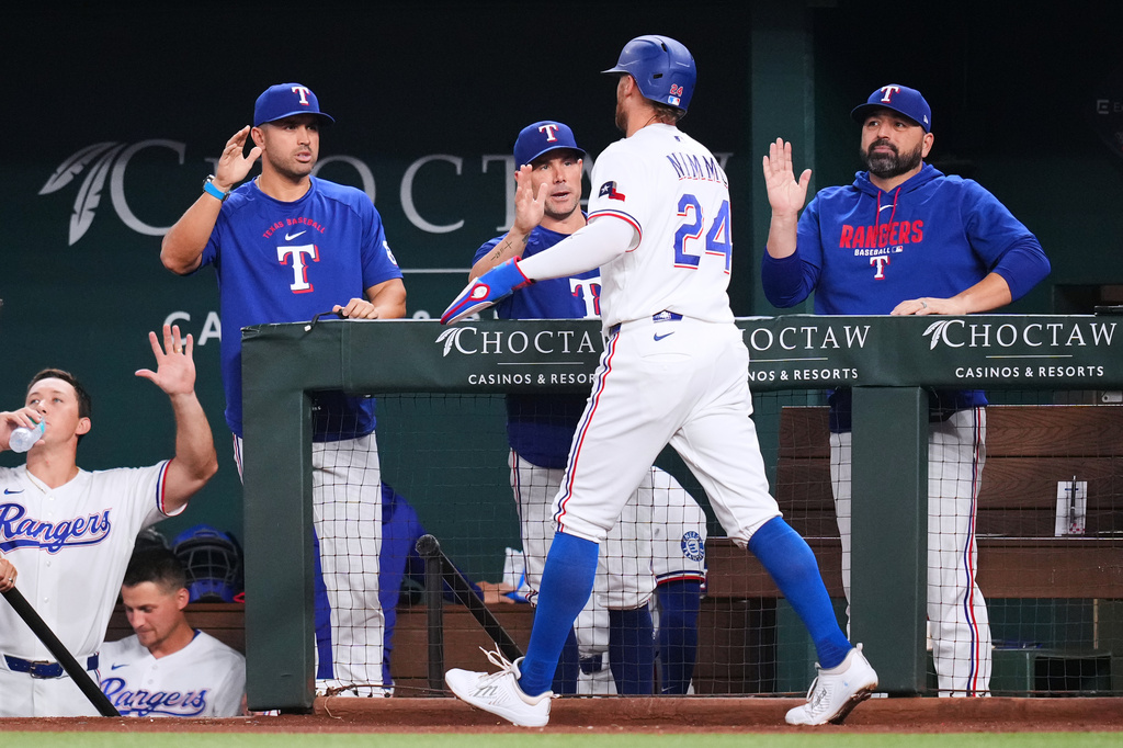 Texas Rangers' Brandon Nimmo (24) is greeted near the dugout after scoring on a single by Elias DÌaz during the second inning of a baseball game against the Athletics Monday, Aug. 31, 2026, in Arlington, Texas. (AP Photo/Julio Cortez)