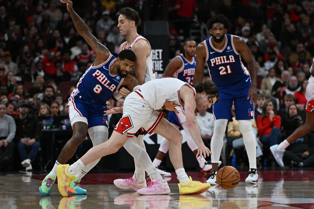 Chicago Bulls' Josh Giddy battles Philadelphia 76ers' Paul George (8) for a loose ball during the first half of an NBA basketball game, Friday, Dec. 26, 2025, in Chicago. (AP Photo/Paul Beaty)