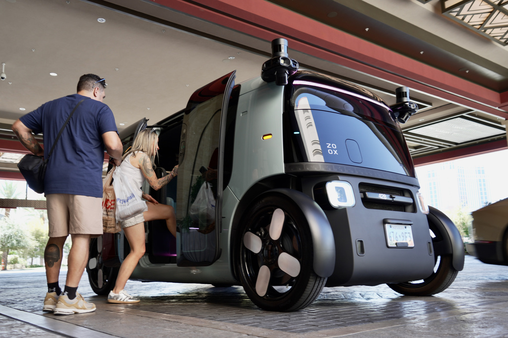 Passengers load into an Amazon Zoox taxi with no steering wheel Thursday, July 30, 2026, in Las Vegas. (AP Photo/Ty ONeil)