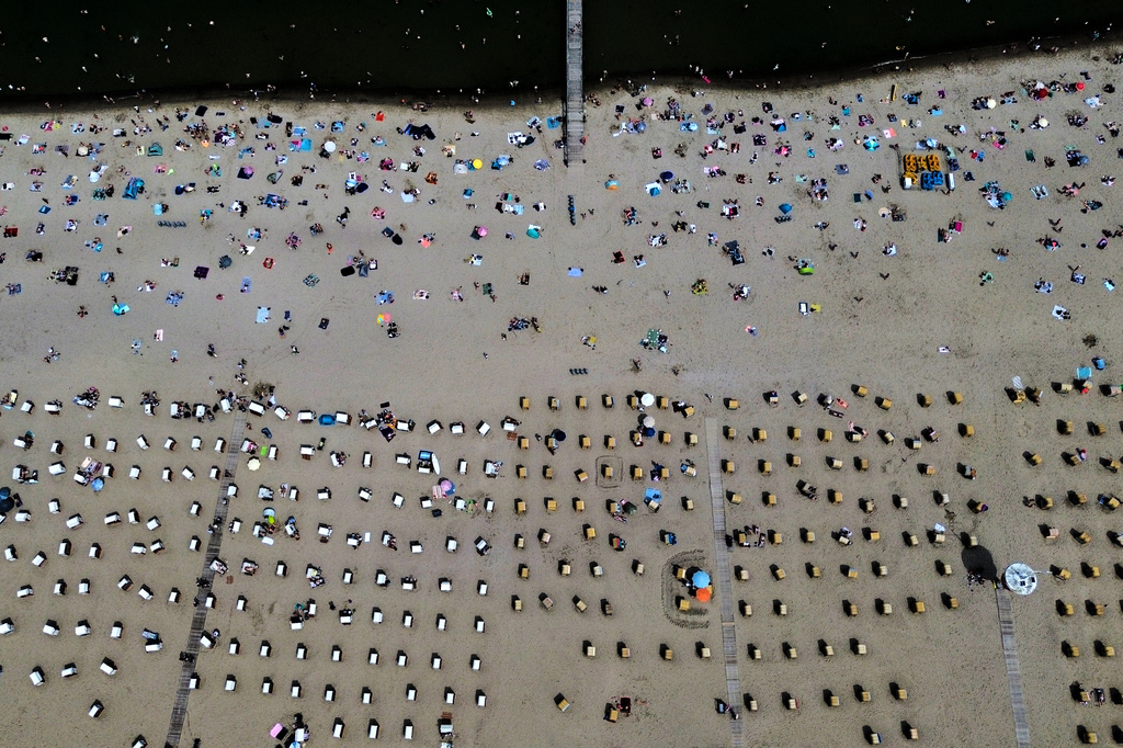 People visit the beach of the Baltic Sea during hot weather in Travemuende, Germany, Saturday, June 20, 2026. (AP Photo/Michael Probst)