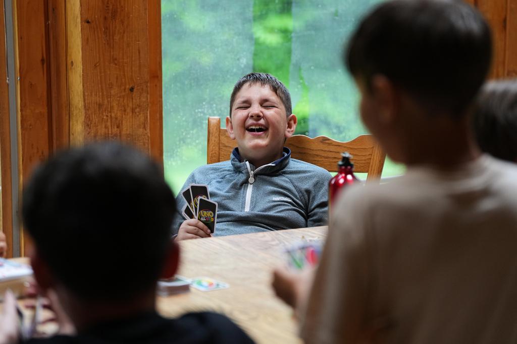 Ethan Blanchfield-Killeen, 11, of Yonkers, N.Y., who has a form of juvenile idiopathic arthritis, plays a card game with bunkmates at the Frost Valley YMCA sleepaway camp in Claryville, N.Y., Thursday, July 31, 2025. The camp partnered with Children's Hospital at Montefiore so kids with autoimmune diseases could attend for the first time. (AP Photo/Matt Rourke)