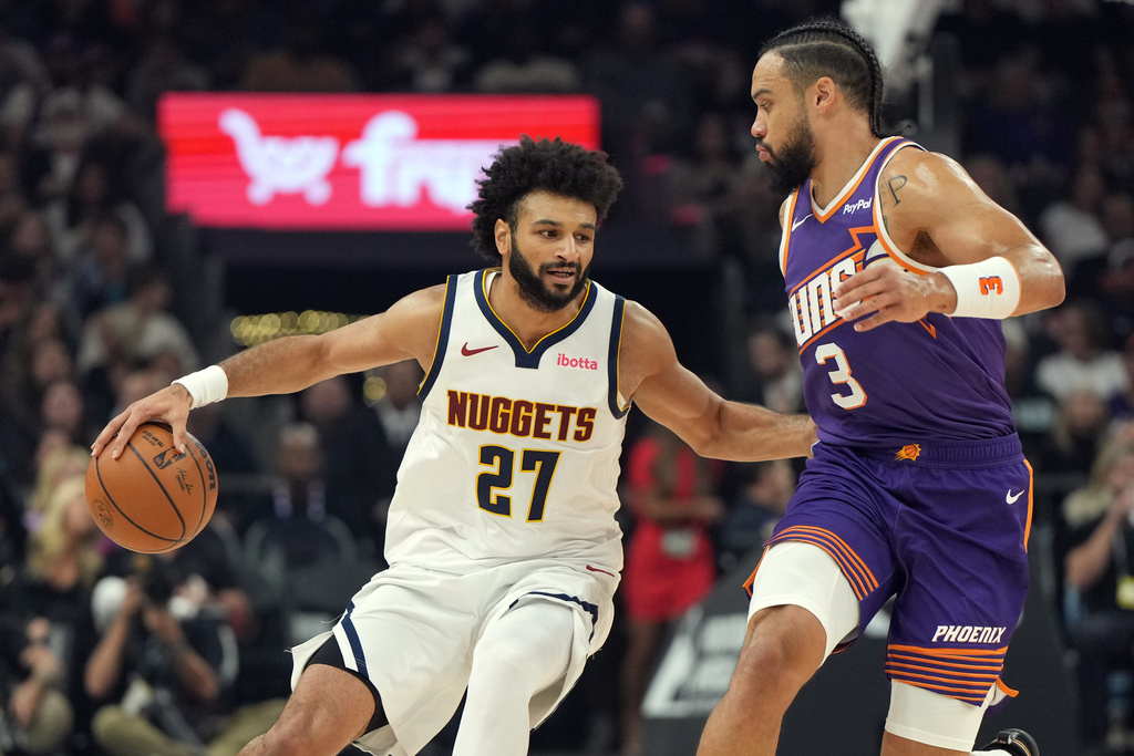 Denver Nuggets guard Jamal Murray (27) drives on Phoenix Suns forward Dillon Brooks during the first half of an NBA basketball game, Saturday, Nov. 29, 2025, in Phoenix. (AP Photo/Rick Scuteri)