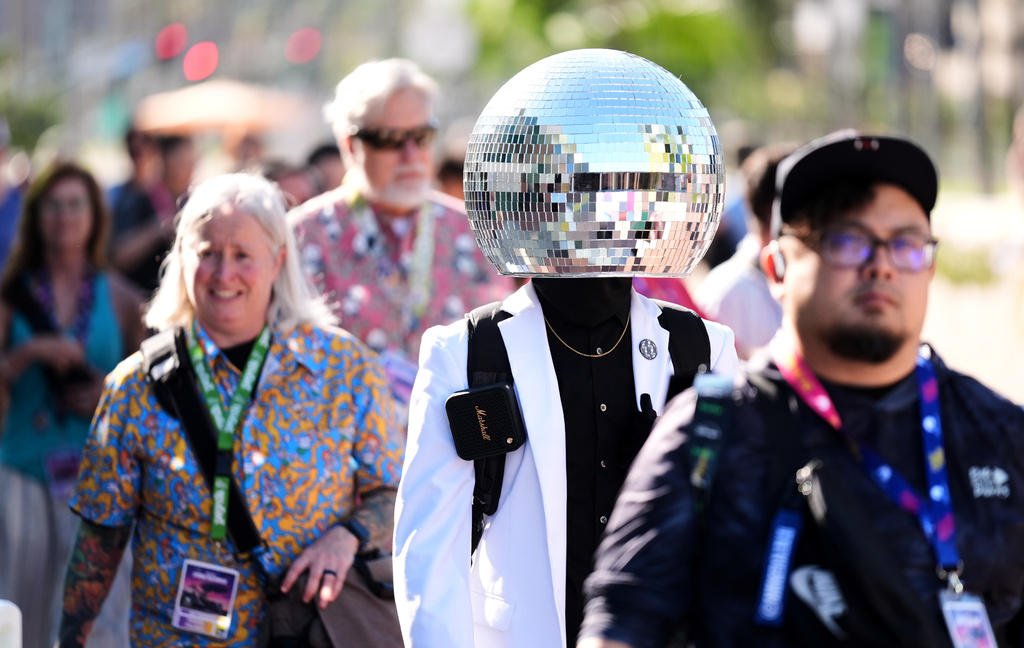 Andrew Ghannadian of San Diego, second from right, dressed as "Discotek," walks alongside fellow Comic-Con attendees during preview night for Comic-Con International on Wednesday, July 22, 2026, in San Diego. (AP Photo/Chris Pizzello)