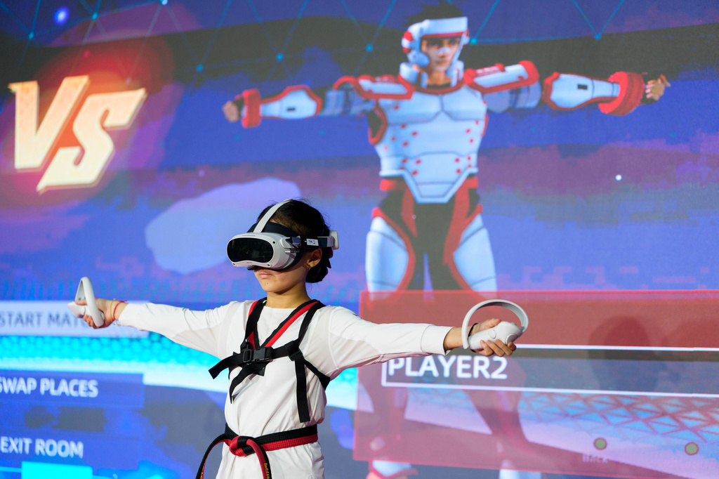 Victoria Siow, 12, calibrates motion-tracking sensors and virtual reality controllers during a virtual taekwondo competition event in Kuala Lumpur, Malaysia, Saturday, June 20, 2026. (AP Photo/Vincent Thian)