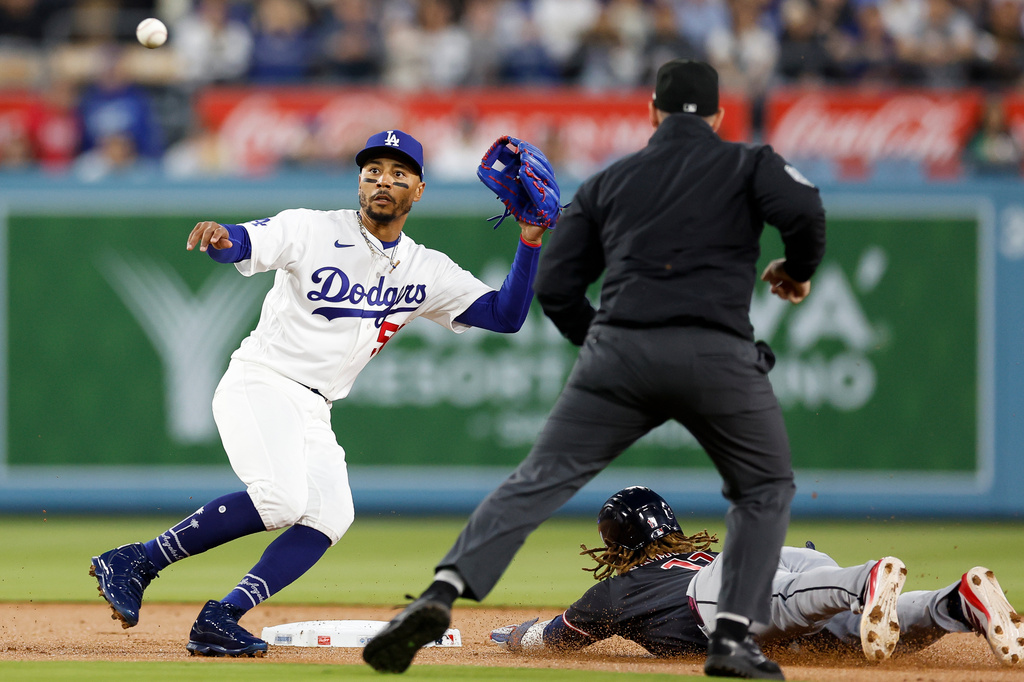 Los Angeles Dodgers shortstop Mookie Betts (50) prepares to catch the ball as Cleveland Guardians Jose Ramirez (11) slides into second base during the first inning of a baseball game Monday, March 30, 2026, in Los Angeles. (AP Photo/Caroline Brehman)