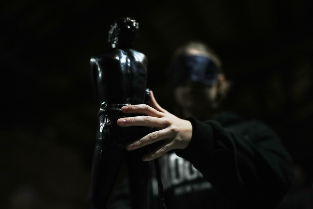 A blindfolded student of an art high school touches a piece in the pavilion of contemporary art during a project on tactile experience at the Omero Tactile Museum in Ancona, Italy, Friday, Jan. 16, 2026. (AP Photo/Alessandra Tarantino)