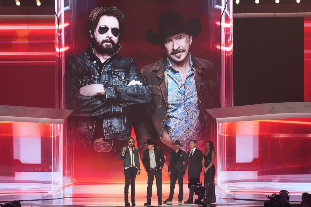 Ronnie Dunn, left, and Kix Brooks of "Brooks & Dunn" accept the award for duo of the year during the 61st annual Academy of Country Music Awards on Sunday, May 17, 2026, at the MGM Grand Garden Arena in Las Vegas. Corey LaJoie and Carl Edwards look on from right.(AP Photo/Chris Pizzello)