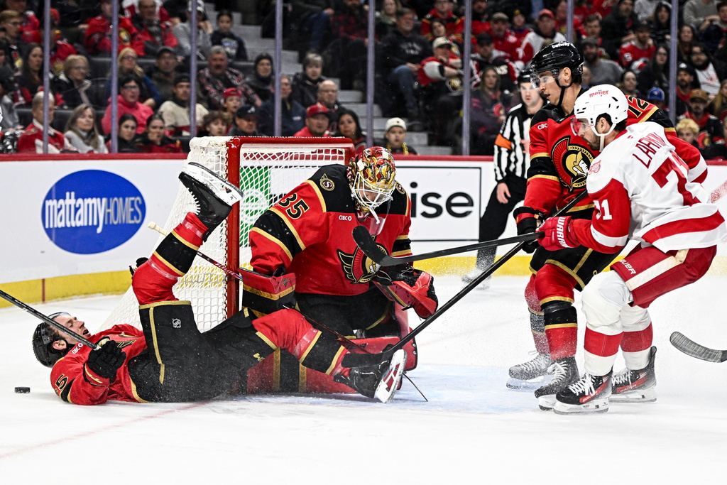 Ottawa Senators' Jake Sanderson (85) crashes to the ice in front of goaltender Linus Ullmark (35) during the first period of an NHL hockey game against the Detroit Red Wings, in Ottawa, Ontario, Thursday, Feb. 26, 2026. (Spencer Colby/The Canadian Press via AP)