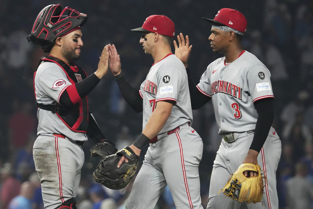 Cincinnati Reds catcher Jose Trevino, left, celebrates with Spencer Steer, center, and Ke