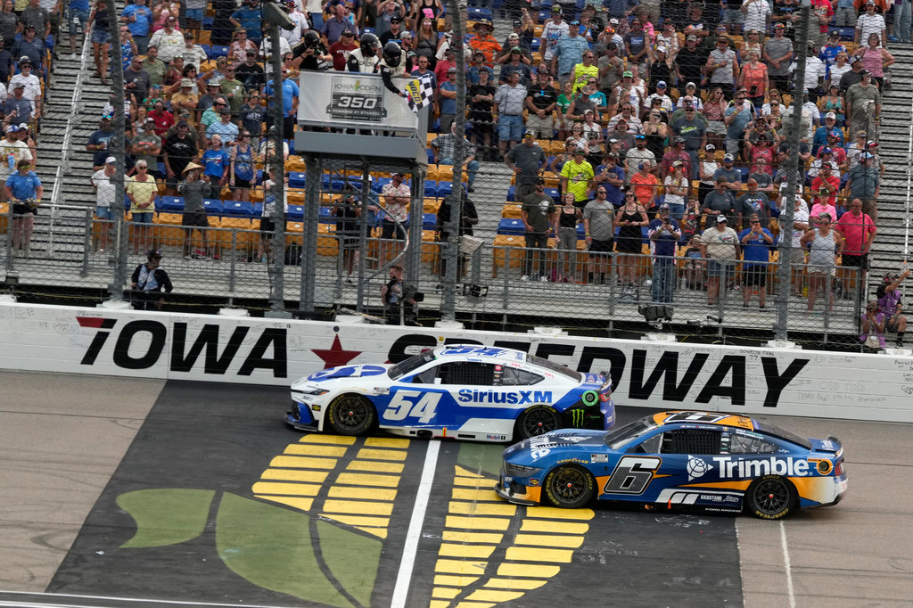 Ty Gibbs (54) crosses the finish line ahead of Brad Keselowski (6) to win a NASCAR Cup Series auto race, Sunday, Aug. 9, 2026, at Iowa Speedway in Newton, Iowa. (AP Photo/Charlie Neibergall)