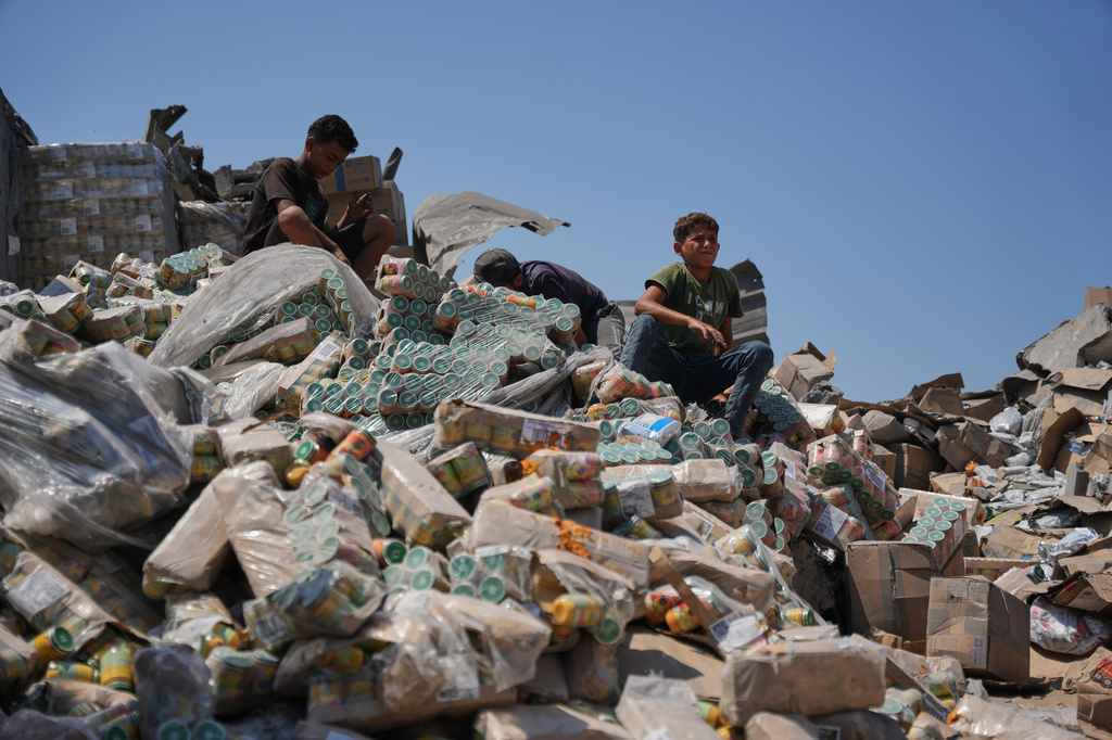 Palestinians look at a food-aid warehouse damaged in an Israeli airstrike that targeted a nearby house in Deir al-Balah, central Gaza Strip, Wednesday, Aug. 26, 2026. (AP Photo/Abdel Kareem Hana)