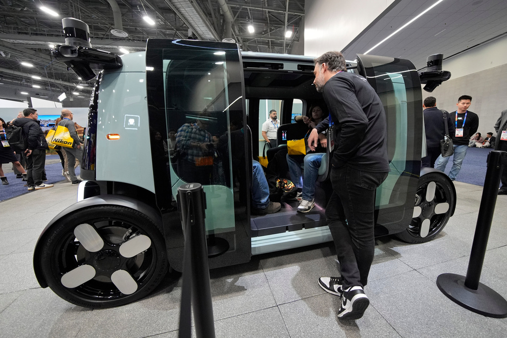 FILE - People view a Zoox self-driving vehicle at the Zoox booth during the CES tech show, Jan. 7, 2025, in Las Vegas. (AP Photo/John Locher, file)