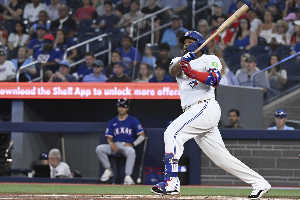 Toronto Blue Jays' Vladimir Guerrero Jr. hits a single against the Texas Rangers in first-inning baseball game action in Toronto, Sunday, Aug. 17, 2025. (Jon Blacker/The Canadian Press via AP)