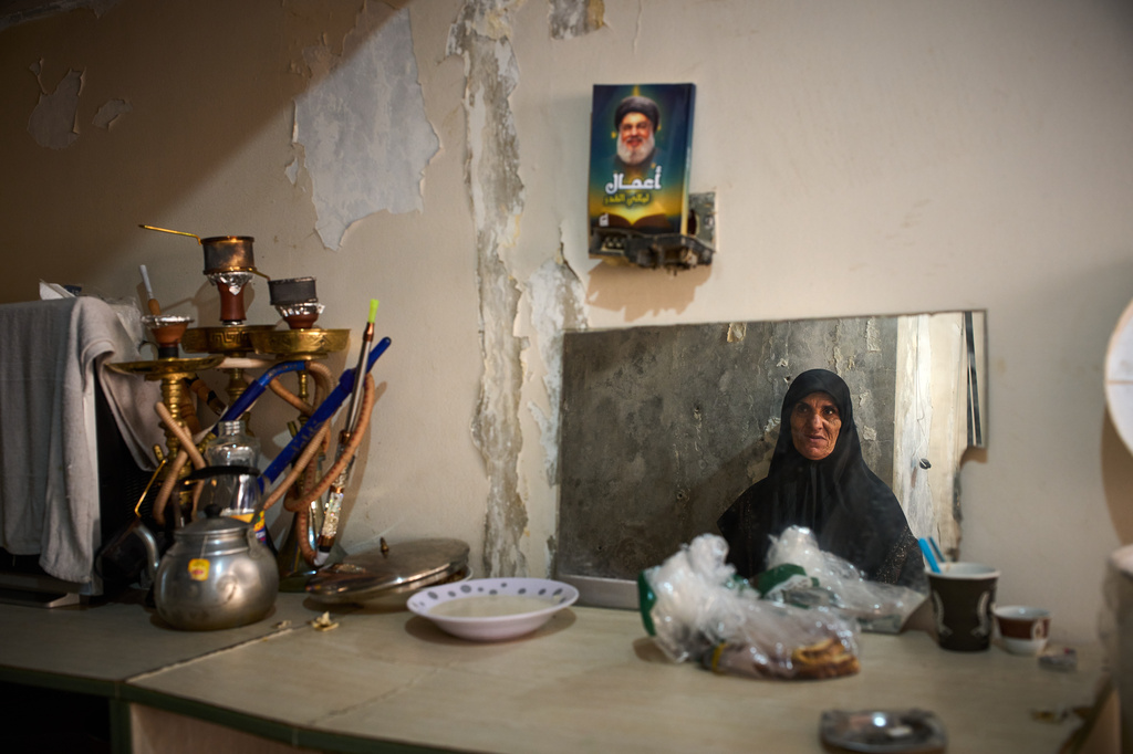 A woman displaced from Beirut's southern suburb of Haret Hreik is seen reflected in a mirror inside a hospital converted into a shelter in Beirut, Lebanon, Friday, March 27, 2026. (AP Photo/Emilio Morenatti)