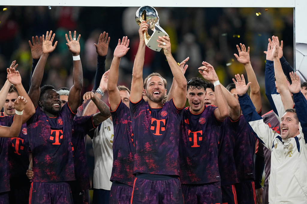Bayern's Harry Kane lifts the trophy after winning the Franz Beckenbauer German Supercup soccer match against Borussia Dortmund in Dortmund, Germany, Saturday, Aug. 22, 2026. (AP Photo/Martin Meissner)