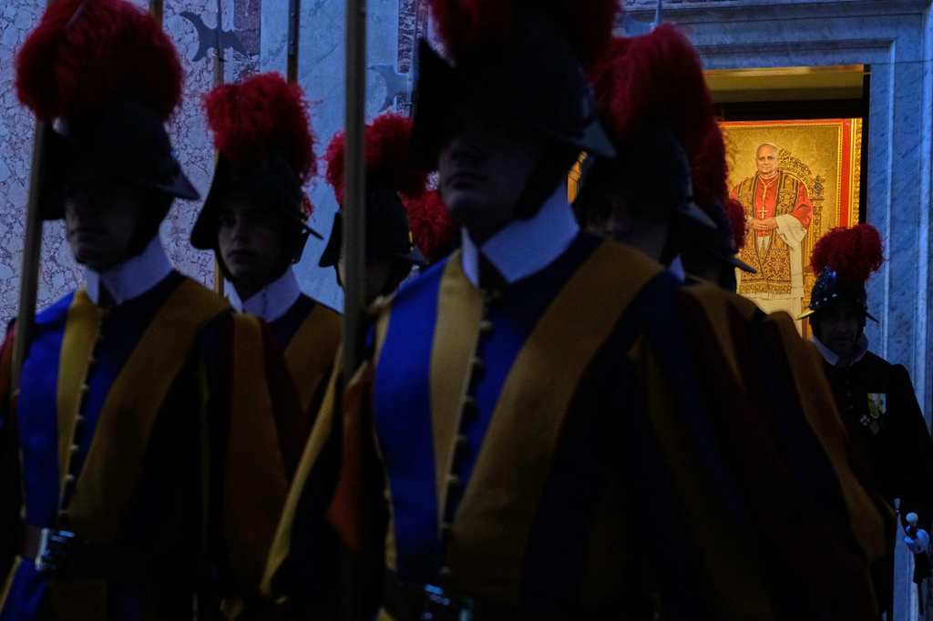 FILE - Pontifical Swiss Guards, backdropped by a portrait of Pope Leo XIV, head into the Courtyard of St. Damasus to await the arrival of King Letsie III of Lesotho at the Vatican, Oct. 17, 2025. (AP Photo/Gregorio Borgia, File)