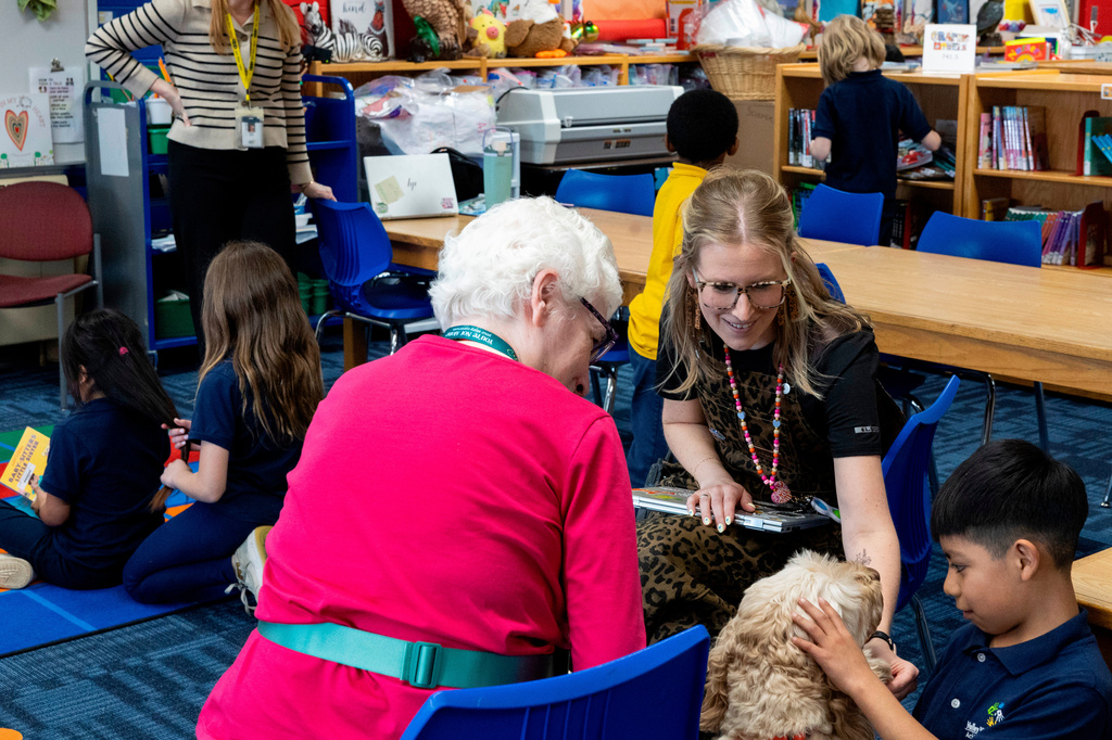 Ian, right, and school social worker Nicole Herje pet Sage, a therapy dog, at Valley View Elementary School on April 29, 2026, in Columbia Heights, Minn. (Ellen Schmidt/MinnPost via AP)