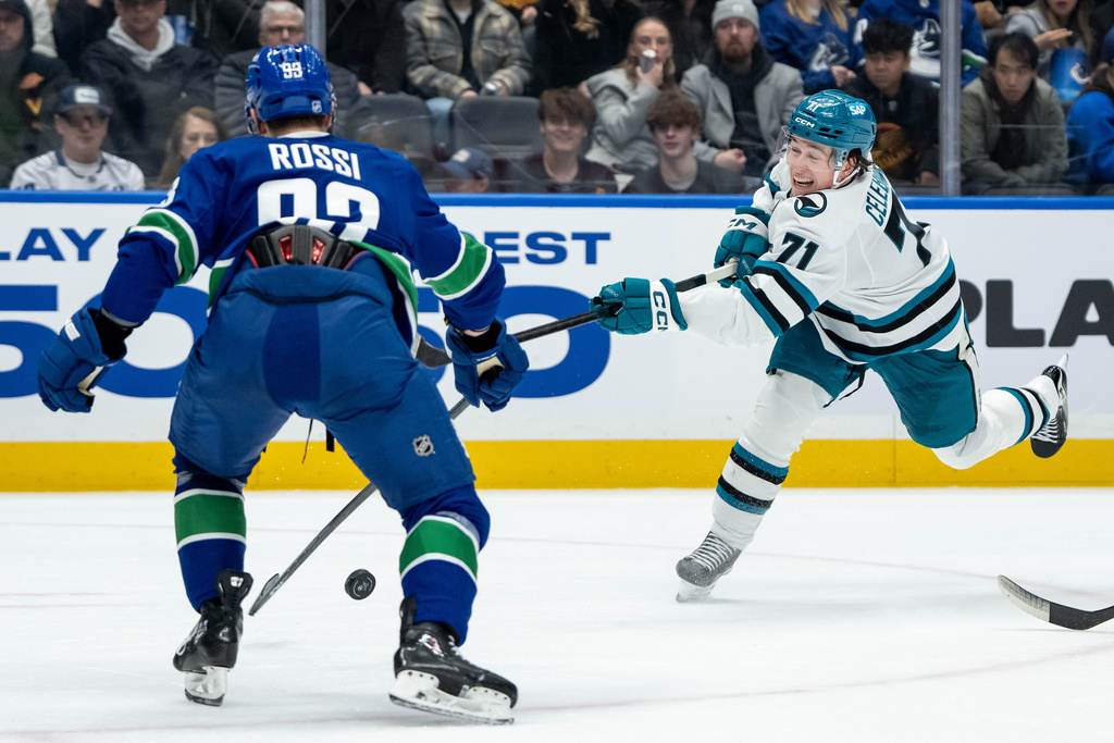 Vancouver Canucks' Marco Rossi (93) blocks a shot by San Jose Sharks' Macklin Celebrini (71) during the second period of an NHL hockey game in Vancouver, British Columbia, Saturday, Dec. 27, 2025. (Ethan Cairns/The Canadian Press via AP)