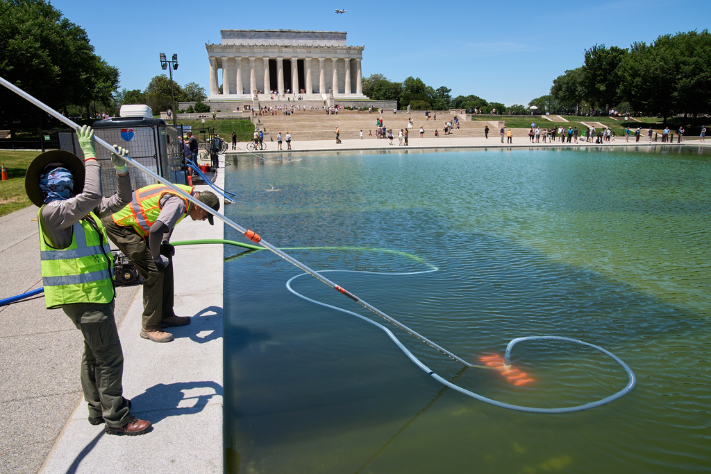 Members of the National Park Service clean algae from the Lincoln Memorial Reflecting Pool, Tuesday, June 16, 2026, in Washington. (AP Photo/Jacquelyn Martin)