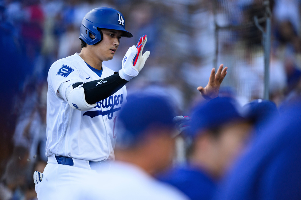 Los Angeles Dodgers' Shohei Ohtani is greeted by teammates after hitting a home run during the first inning of a baseball game against the Arizona Diamondbacks, Friday, July 10, 2026, in Los Angeles. (AP Photo/William Liang)