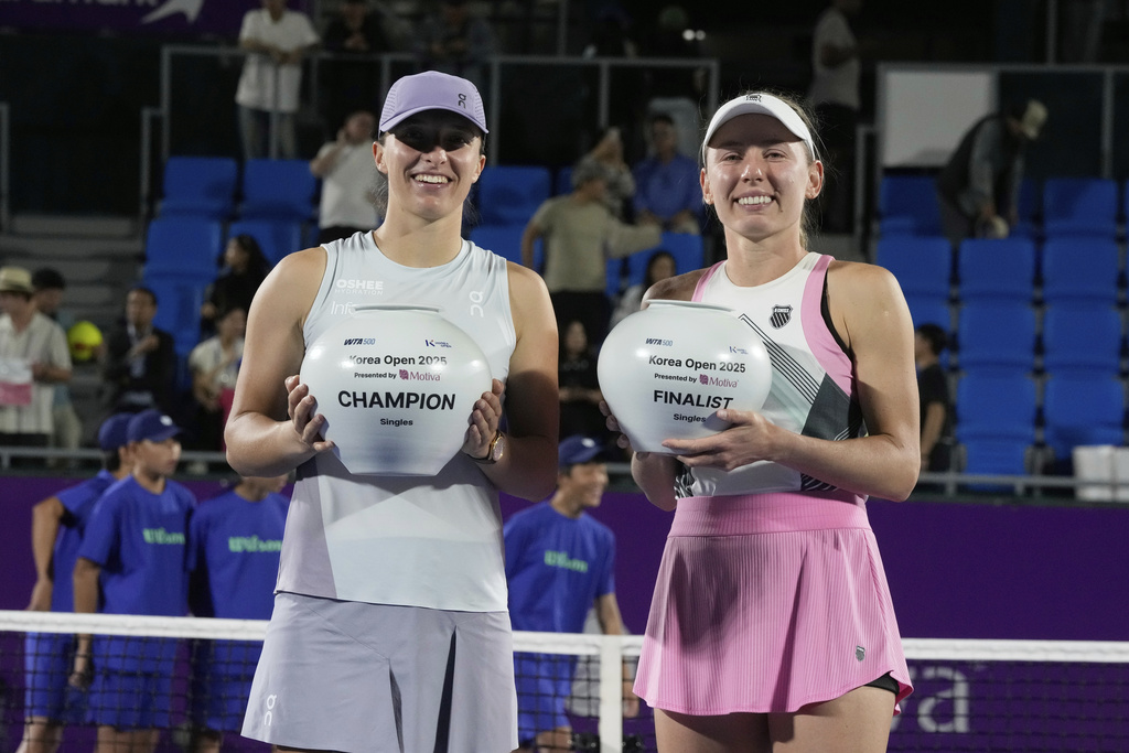 Iga Swiatek, left, of Poland holds her trophy with runner-up Ekaterina Alexandrova of Russia after the final match of the Korea Open tennis championships at Seoul Olympic Park Tennis Center in Seoul, South Korea, Sunday, Sept. 21, 2025. (AP Photo/Ahn Young-joon) I